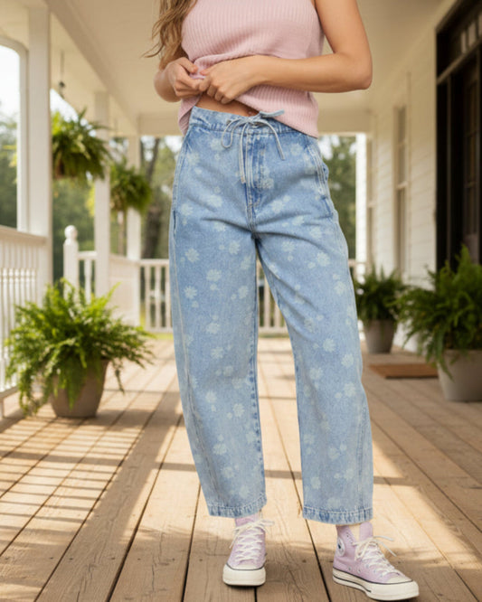 Person wearing light blue jeans and pink shoes standing in front of a yellow couch.